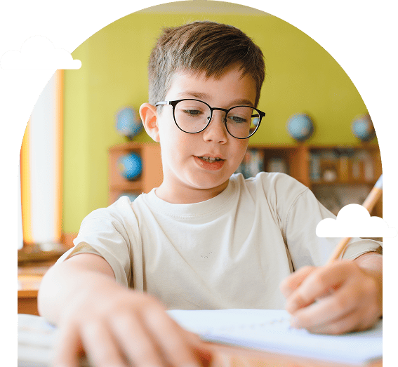 a-young-boy-with-glasses-writes-at-a-desk-in-a-classroom